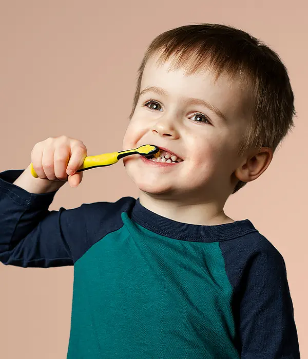 Kid brushing their teeth to prevent cavities
