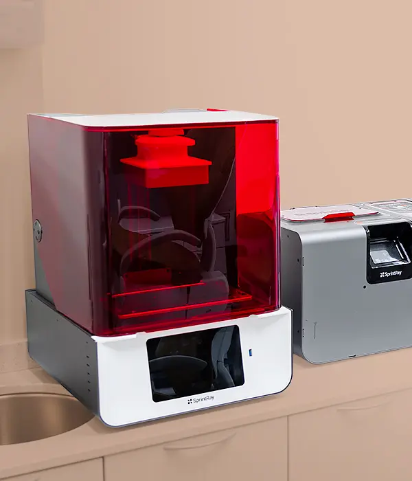 Modern dental 3D printing equipment with a red-tinted cover and digital interface, showcasing advanced in-office technology used for efficient, high-precision dental treatments.