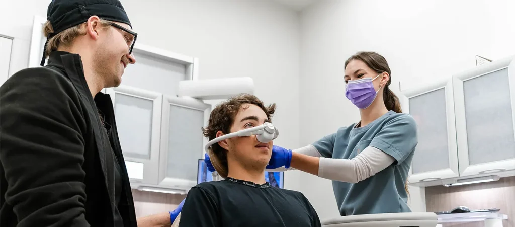 Dental team preparing a teenage patient for nitrous oxide sedation in a modern dental clinic.